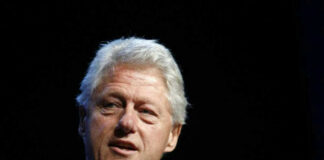 Man with gray hair speaking at an event.