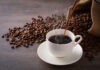 Botulism Warning Hits THIS Coffee? Cup of hot coffee being poured beside scattered coffee beans