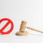 Maxwell’s ‘Rigged Trial’ Claim OBLITERATED Wooden judge's gavel beside a red prohibition symbol