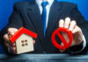 Rich Buyers Feast, Starter Dreams Stall Businessman holding house model and prohibition sign