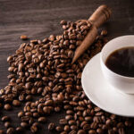 Kid Caffeine Surge Alarms CDC A cup of hot coffee next to spilled coffee beans and a wooden scoop