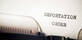 Close-up of a typewriter with a paper showing the words 'DEPORTATION ORDER'