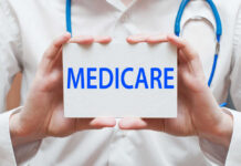 A medical professional holding a sign that says MEDICARE