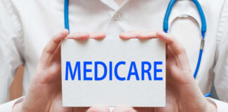 A medical professional holding a sign that says MEDICARE
