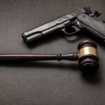 Texas Judge Guts 90-Year Gun Law Pistol and judge's gavel on dark surface