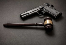 Texas Judge Guts 90-Year Gun Law Pistol and judge's gavel on dark surface