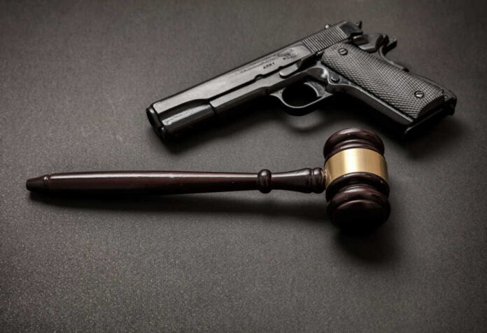 Law,,Crime,,Punishment,Concept.,Judge,Gavel,And,A,9mm,Pistol Pistol and judge's gavel on dark surface