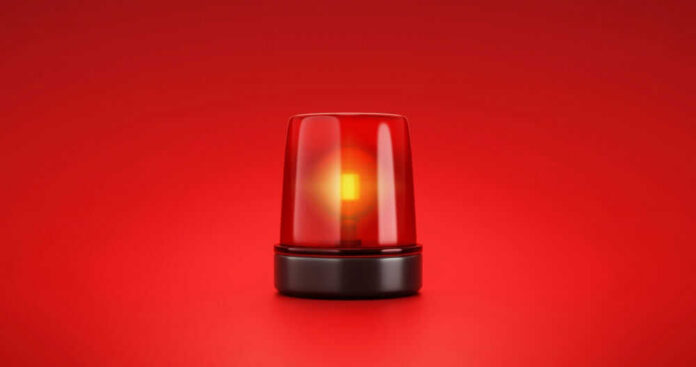 shutterstock_2053758056 Red emergency light on red background