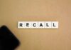 Letter tiles spelling recall on cardboard with a smartphone corner