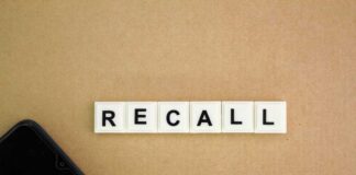 Letter tiles spelling recall on cardboard with a smartphone corner