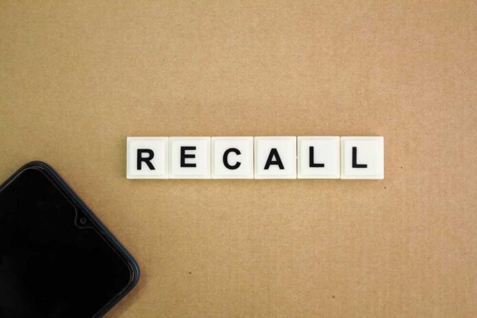 Letter tiles spelling recall on cardboard with a smartphone corner