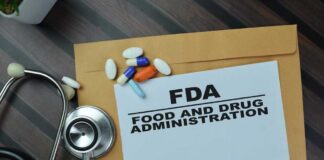 FDA document with pills and a stethoscope on a wooden surface