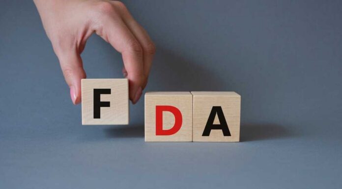 Fda,-,Food,Drug,Administration,Symbol.,Wooden,Cubes,With,Word A hand holding a wooden block with the letter F, next to blocks spelling FDA