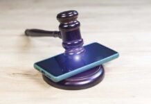 Teen Suicides Drag Big Tech to Court Judge’s gavel resting on a smartphone on a wooden surface