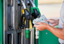 Pump Shock: $4 Gas Gut-Punches Confidence Person holding cash at a gas station while preparing to refuel