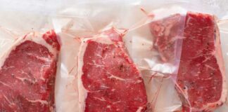 Three vacuum sealed steaks on a white surface