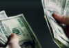 Cash Frenzy Erupts In U.S. Cities Hands holding and counting stacks of cash