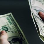 Cash Frenzy Erupts In U.S. Cities Hands holding and counting stacks of cash