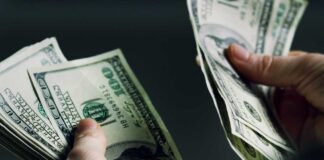 Hands holding and counting stacks of cash