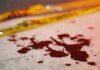 Two-Scene Bloodbath Stuns Nation Blood droplets on pavement near yellow caution tape