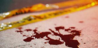 Blood droplets on pavement near yellow caution tape
