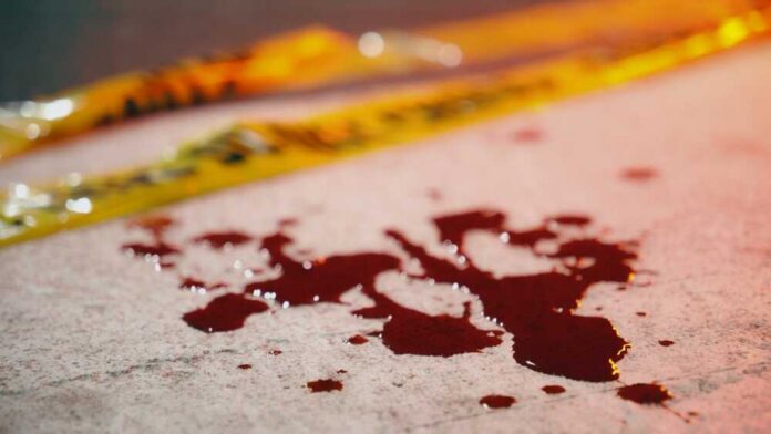 Close-up,Of,Blood,Stains,On,Crosswalk,Asphalt,Near,Yellow,Police Blood droplets on pavement near yellow caution tape