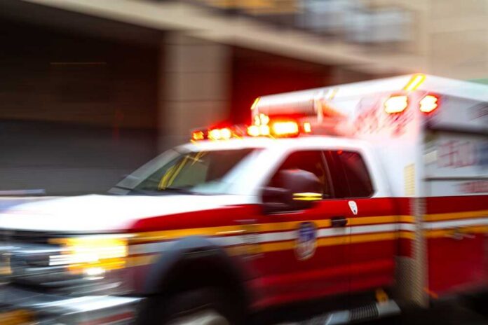 A,Blurred,Ambulance,Races,Through,The,Bustling,Streets,Of,New Ambulance with flashing lights speeding through a city street