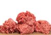 Two raw ground meat patties on a dark surface