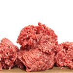 Grass-Fed Gamble Shocks Fast Food Two raw ground meat patties on a dark surface