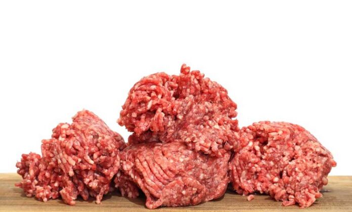 Pile,Of,Fresh,Raw,Minced,Meat,On,Wooden,Board,Isolated Two raw ground meat patties on a dark surface