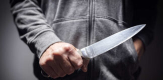 A person holding a knife in a threatening manner