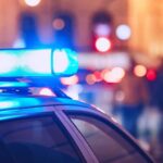 VIDEO: Pre-Dawn Carnage Leaves 23 Dead Close-up of a police car with blue emergency lights in a city at night