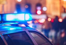 VIDEO: Pre-Dawn Carnage Leaves 23 Dead Close-up of a police car with blue emergency lights in a city at night