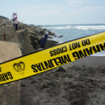 Lake Mead Horror — What Surfaced Now? Yellow police tape by rocky ocean shore