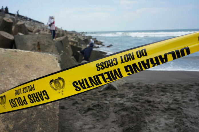 shutterstock1599290890jpg Yellow police tape by rocky ocean shore
