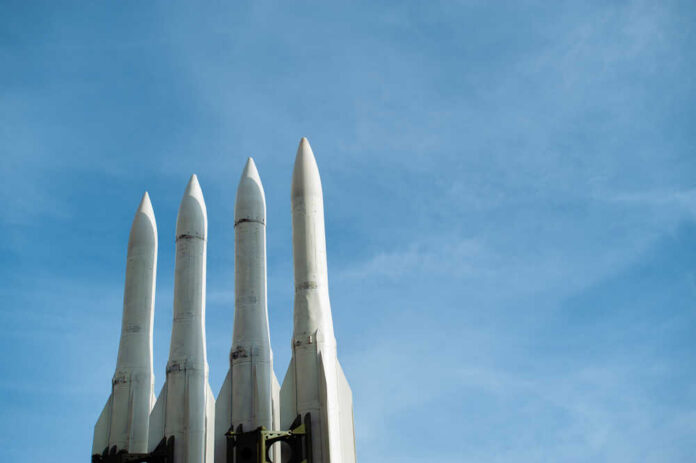 Several,Combat,Missiles,Aimed,At,The,Sky.,Missile,Weapons.,Nuclear Four white missile launchers pointing upward against a blue sky