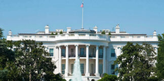 The White House, front view with fountain and flag.