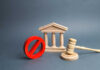 Wooden courthouse with red prohibition symbol and judge’s gavel