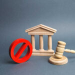 Wooden courthouse with red prohibition symbol and judge’s gavel