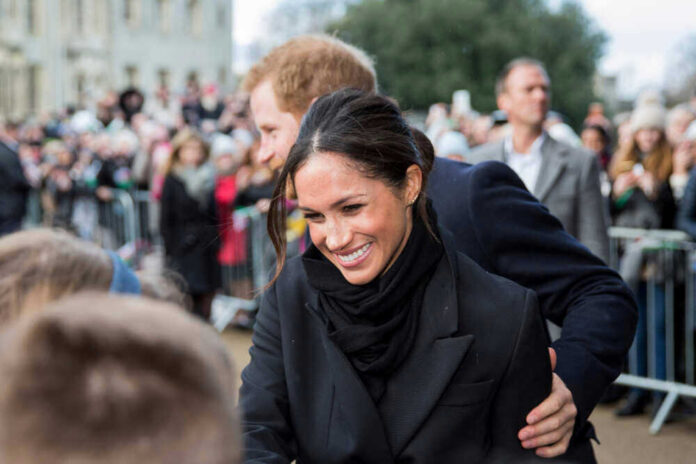 shutterstock_1559827346 A woman smiling and interacting with a crowd.