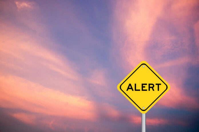 Yellow,Transportation,Sign,With,Word,Alert,On,Violet,Sky,Background Yellow alert sign against a colorful sunset sky