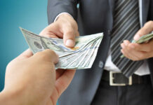 Funflation Strikes: Pay More, Play Less? A person handing over a stack of cash to another individual in a suit