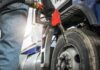 Person fueling a large truck with a gas pump