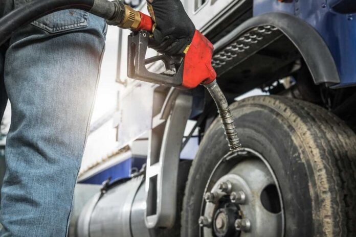 Aged,Semi,Truck,Driver,About,To,Refuel,His,Tractor,Truck Person fueling a large truck with a gas pump
