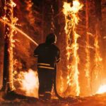 Arson Hits Resort Paradise Firefighter battling a raging forest wildfire at night
