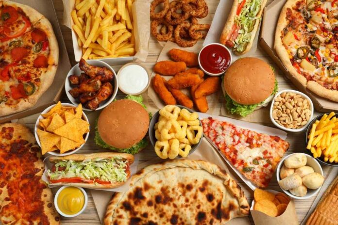 French,Fries,,Pizza,And,Other,Fast,Food,On,Wooden,Table, Exterior view of a Hardee's restaurant with a black car parked in front