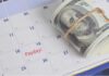 32-Hour Pay Mandate Sparks Cost Panic A rolled bundle of cash placed on a calendar marked with 'Payday!'