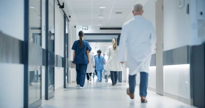 Hospital,Hallway,With,Doctors,,Nurses,And,Specialists,In,Hospital.,Female Medical staff walking through a hospital corridor
