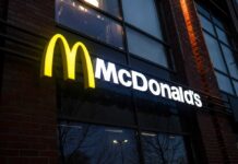 McDonald’s Drops $8.5B On THIS!? Illuminated McDonald's sign on a brick building at night