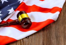 Judge’s Chilling Rebuke Gets Courtroom Applause A gavel resting on an American flag